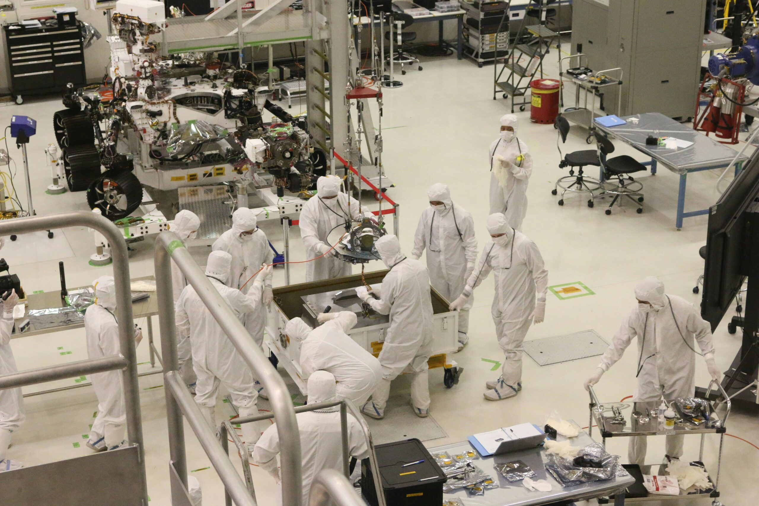 Scientists in cleanroom suits working on advanced materials in a high-tech laboratory.