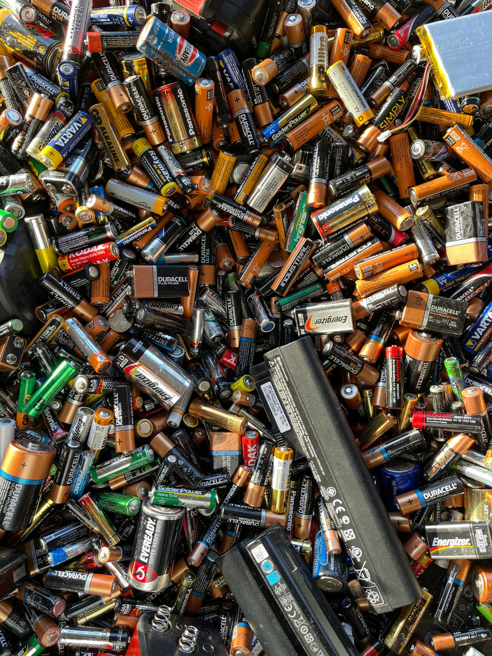 A collection of various used batteries, including alkaline, lithium-ion, and rechargeable types, highlighting the role of cobalt compounds in energy storage.