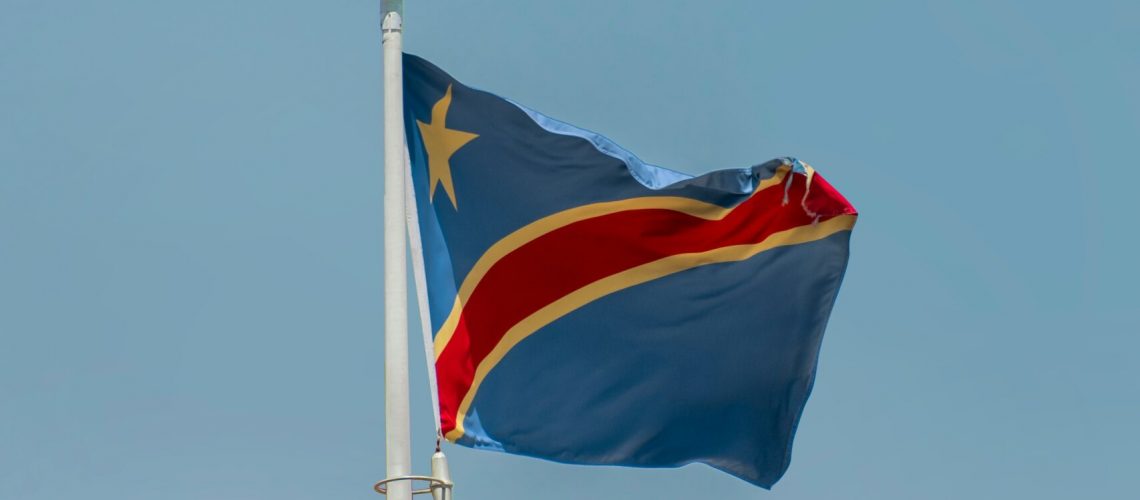 The national flag of the Democratic Republic of the Congo (DRC) waving against a clear blue sky, symbolizing the nation’s rich cobalt resources and strategic role in global supply chains amid evolving export policies.