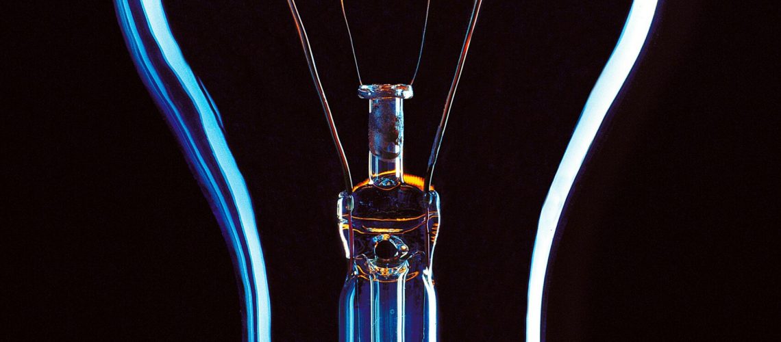 Close-up of an illuminated incandescent light bulb with visible filament, emphasizing the role of Molybdenum (IV) Sulfide in electrical applications.