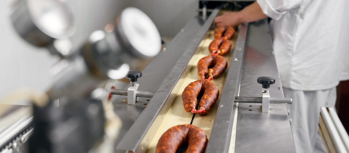 worker on an sausage that has had sodium nitrite added it it, assembly line at a meat packing facility