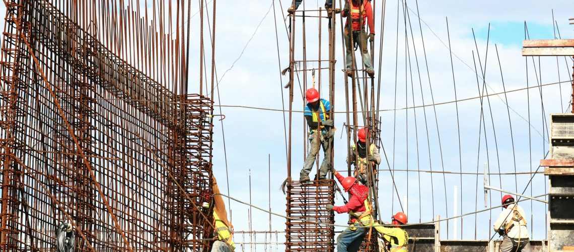 Construction workers using dextrose-enhanced drywall, showcasing its role in improving the strength and efficiency of modern building structures.