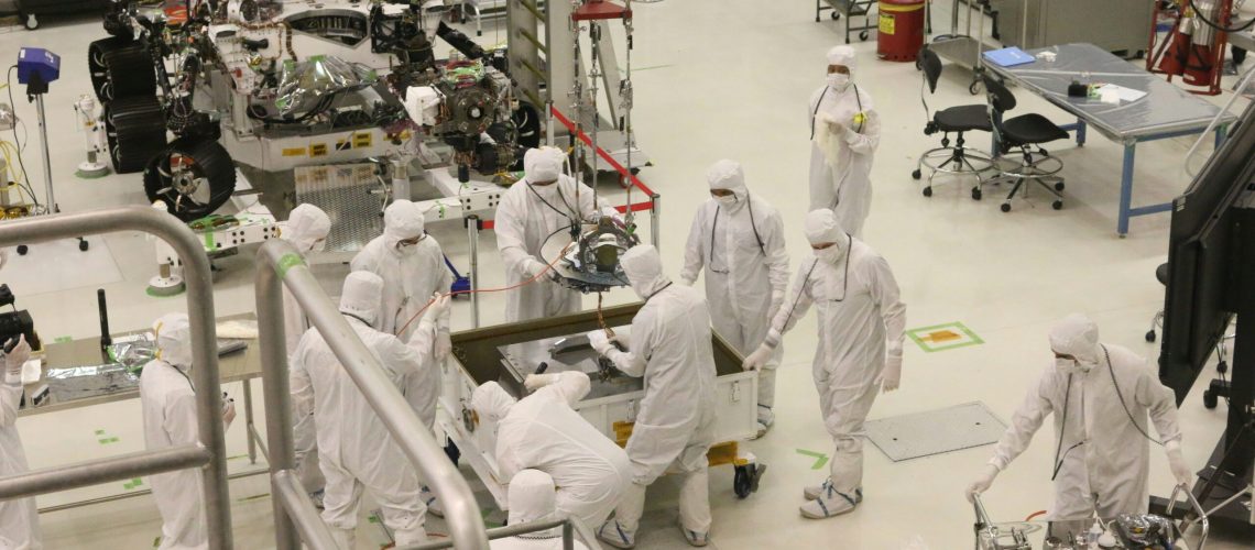 Scientists in cleanroom suits working on advanced materials in a high-tech laboratory.