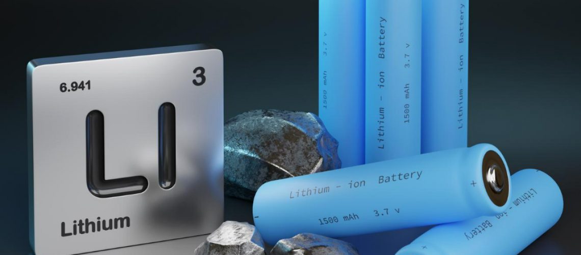 A chemical element plaque for lithium displayed next to lithium ion batteries and chunks of carbon, graphite.
