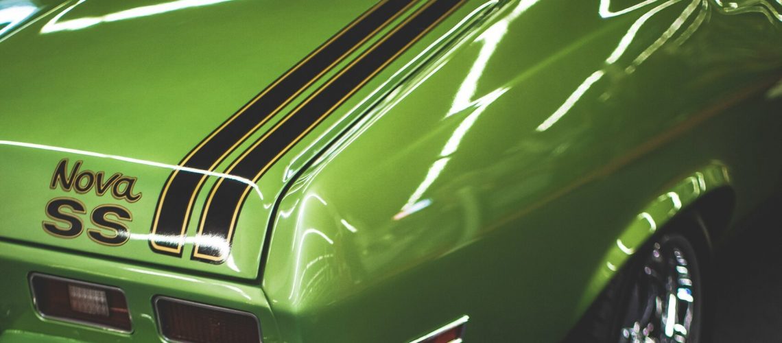 Close-up of the rear end of a vibrant green vintage car with 'Nova SS' branding, showcasing the glossy, durable finish.